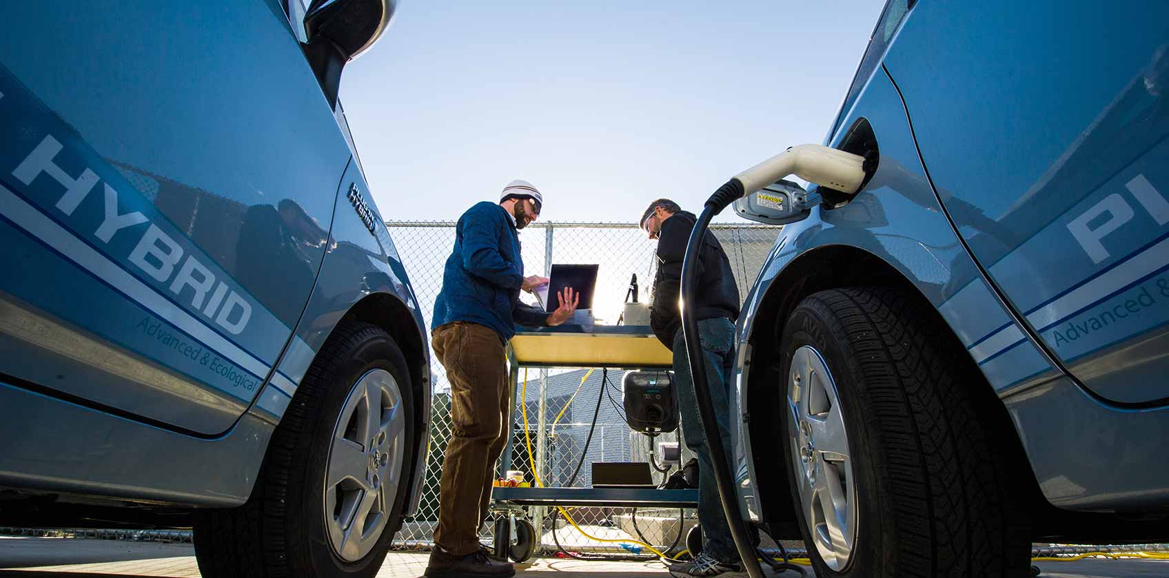 Photo of two men working on testing electric vehicle technologies