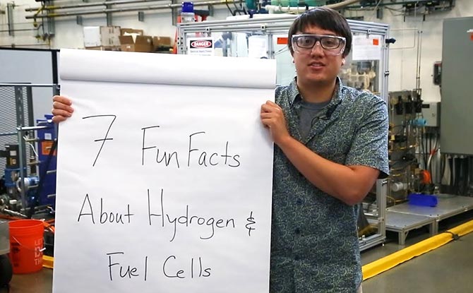 An employees hold a sign that says "7 Fun Facts About Hydrogen"