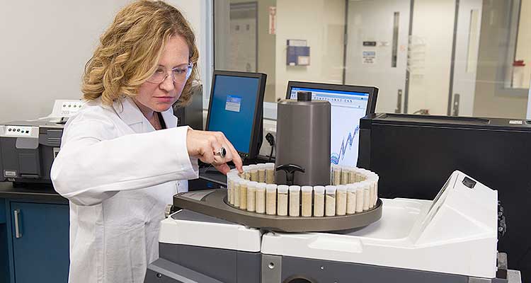 woman in lab looking at turn table of samples