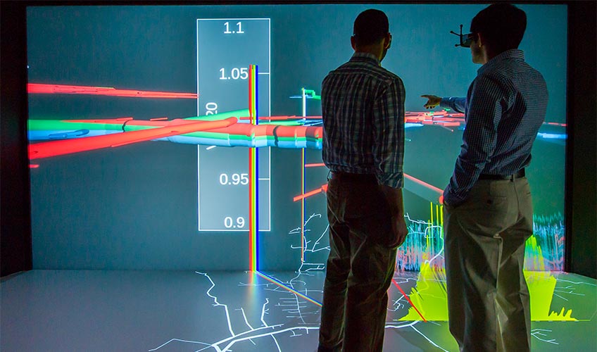 Two people looking at a data visualization projected on a screen