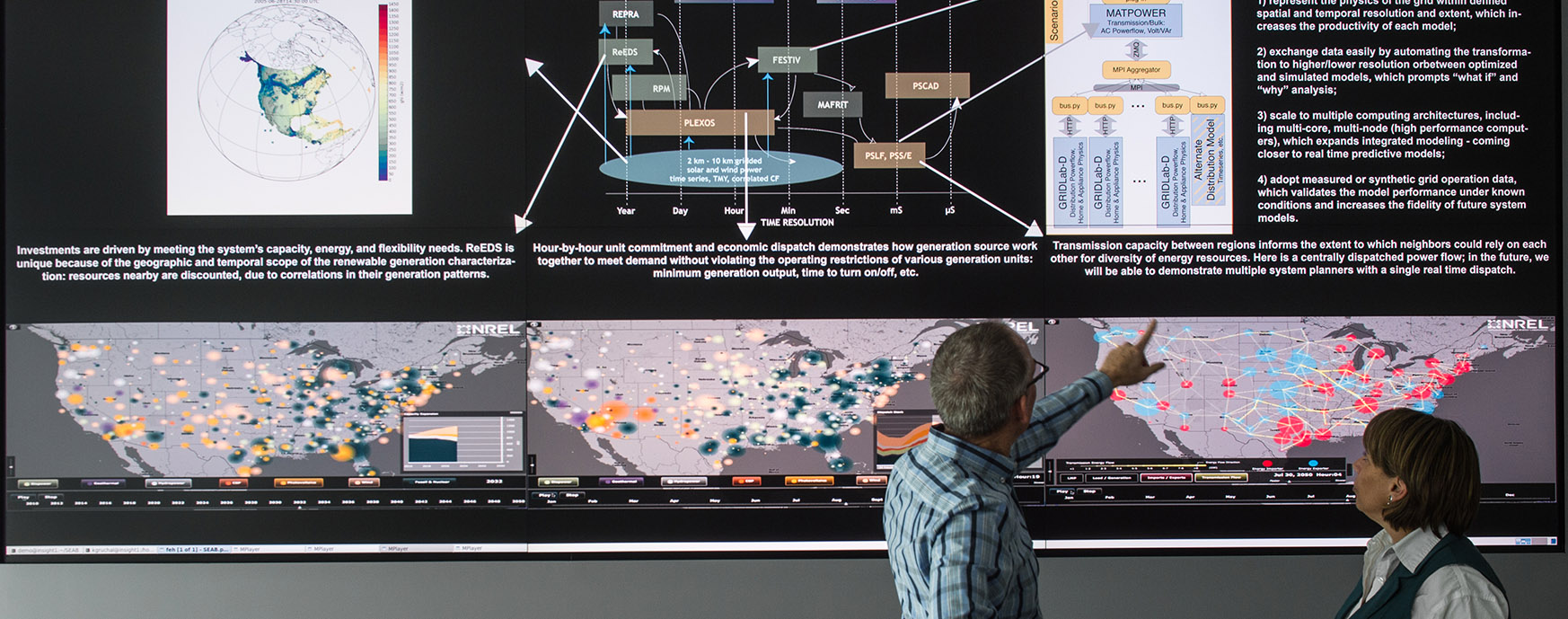 Photo of researchers inspecting maps on a large display.