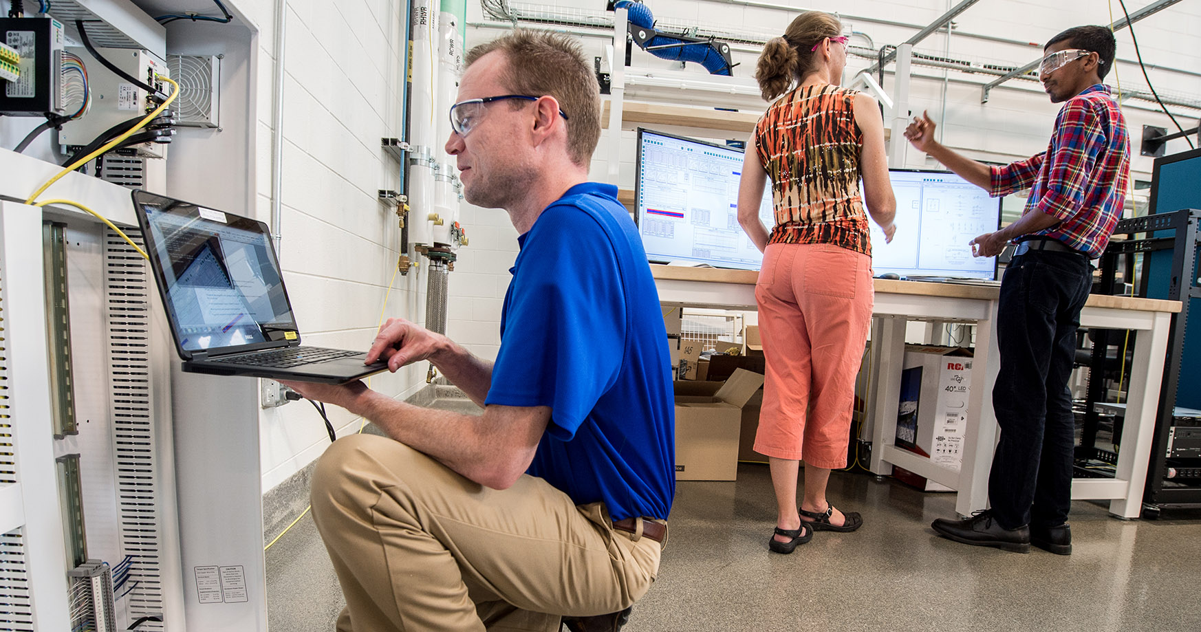 NREL researchers work on controller- and power hardware-in-the-loop test setups to evaluate the performance of microgrid controllers.