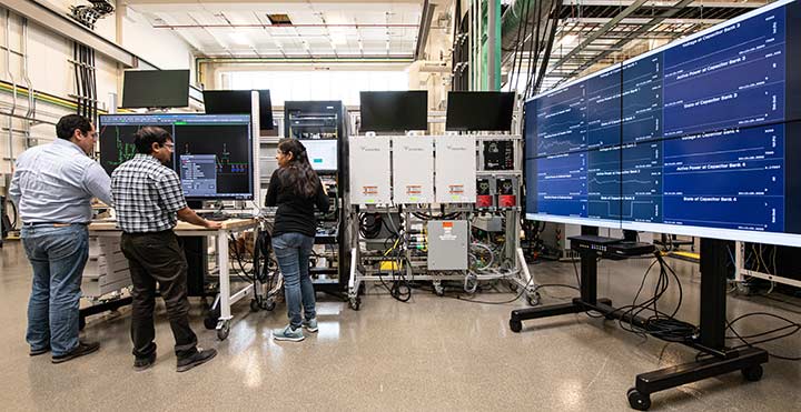 NREL researchers work on the ADMS Test Bed in the Power Systems Integration Lab in the ESIF. 