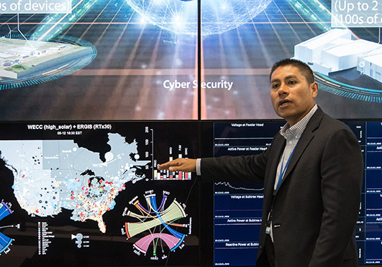 NREL Associate Laboratory Director for Energy Systems Integration Juan Torres points to map displaying renewable energy generation data across the United States.