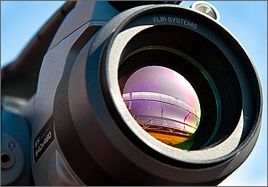 This is an extreme close-up of the lens of an infrared camera, with the mirrors it is pointing at clearly visible in the lens's glass.