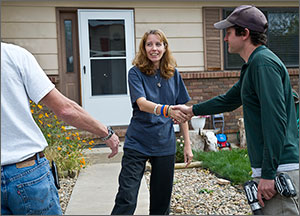 Photo of a woman shaking hands with a weatherization professional.