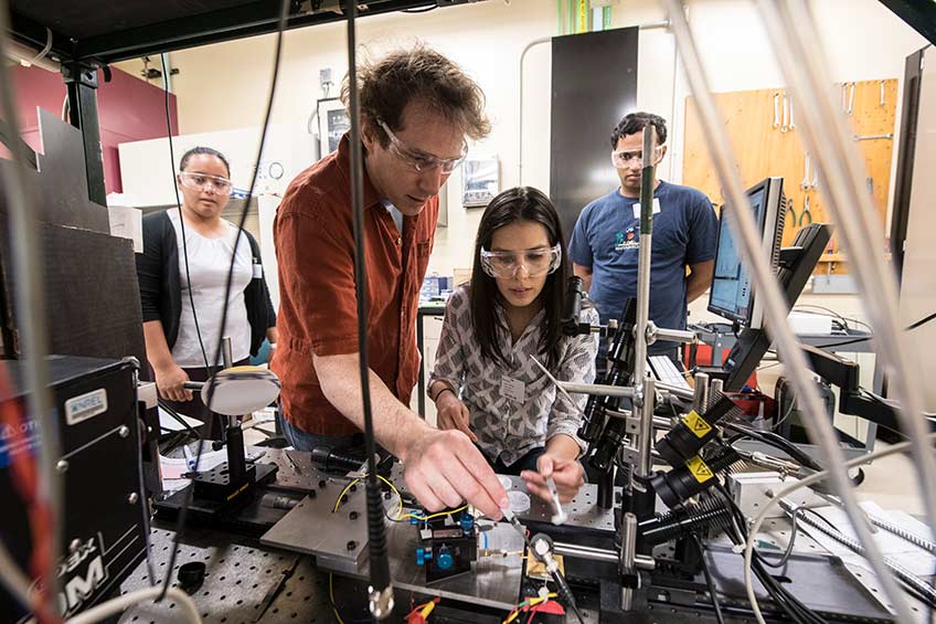 Scientists work on lab equipment