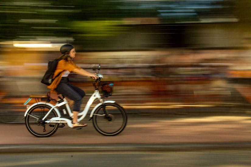 Photo of person riding bike in city setting.