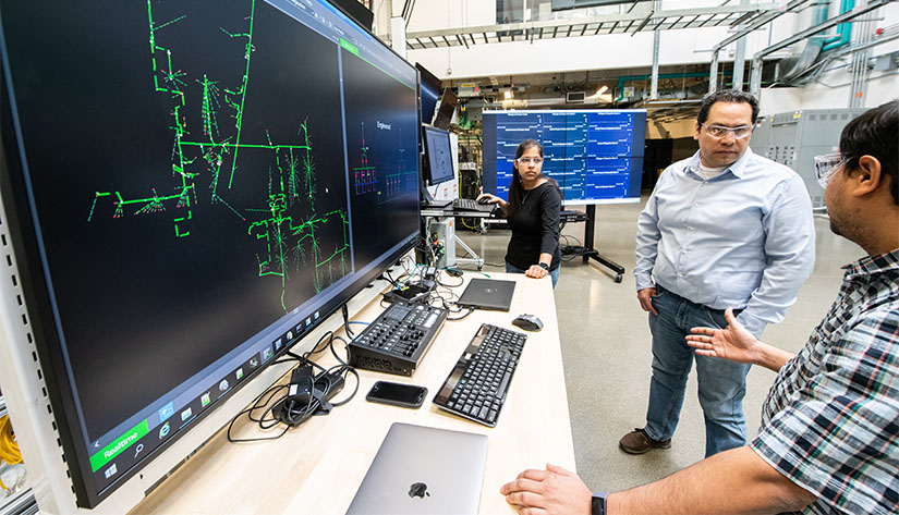NREL Researchers work on the ADMS Test Bed in the Power Systems Integration Lab.