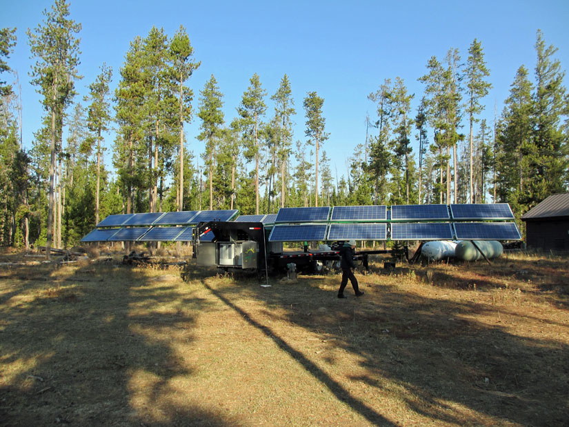 Alicen Kandt walks in front of a mobile photovoltaic system in Yellowstone National Park. The system provides power to Bechler Ranger Station.