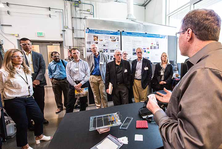A researcher explains internal short circuit research to USCAR directors on a tour of the ESIF at NREL