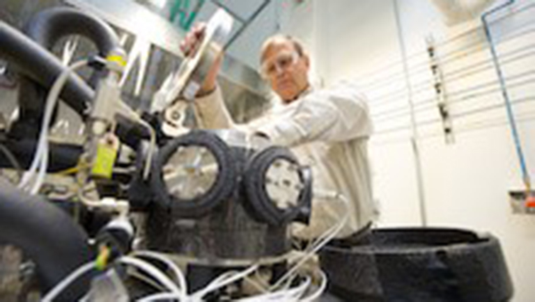 PA researcher works on the sensor test apparatus for testing hydrogen safety sensors in NREL's Hydrogen Sensor Test Lab