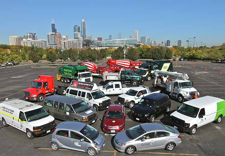 Photo showing multiple alternative fuel vehicles, from sedans to vans, to heavy-duty trucks, with the Chicago skyline in the background.