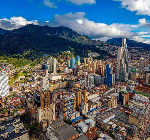 Aerial view of skyscrapers in Colombian city with mountains in the background.