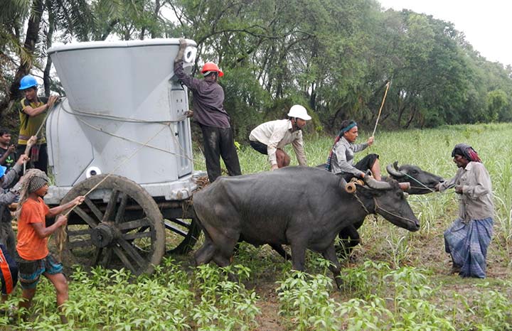 A group of men transporting a meteorological instrument by ox cart across a field.