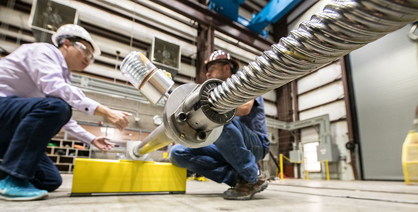 Photo of two researchers in a lab testing a wave energy converter.