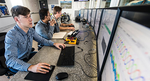 NREL researchers work on microgrid integration analysis in the controllable grid interface control room.