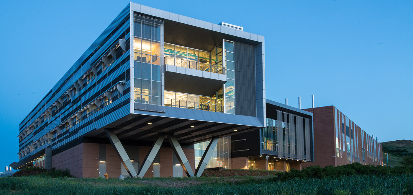 An evening photograph of the Energy Systems Integration Facility on NREL's campus.