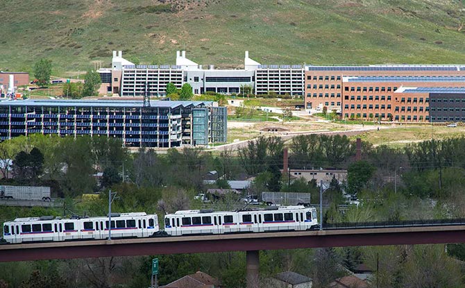Denver light rail running with NREL campus in the background.
