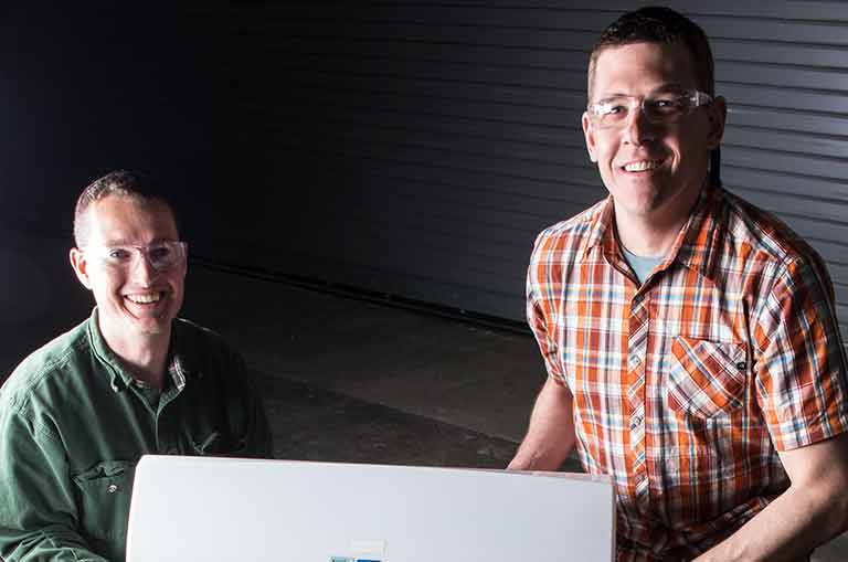 NREL engineers Chuck Booten and Jon Winkler with the EcoSnap AC in their lab.