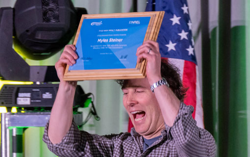 A person lifting a plaque above their head.'