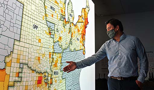 A man points to a large modeling map of the United States