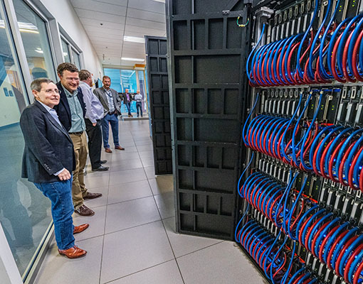 People standing inside laboratory looking at Kestrel high-performance computing system.