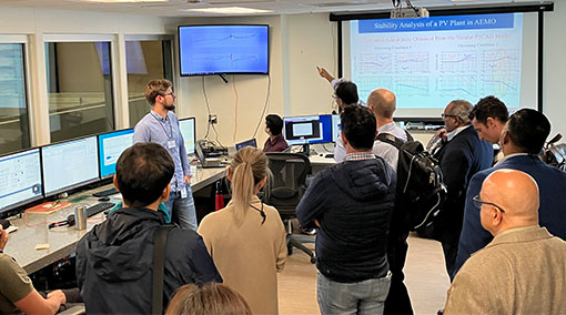 Group of visitors tour lab and look at data presented on screens.