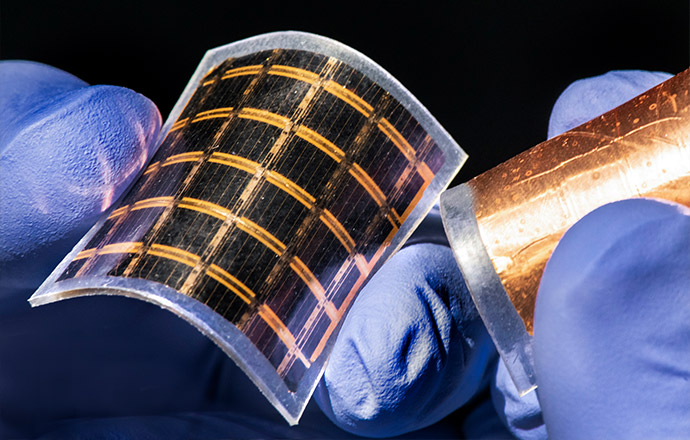 Photo of flexible solar cells held in gloved hands