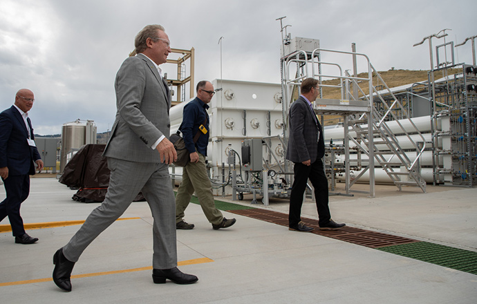 Photo of four people walking outside next to a hydrogen research facility