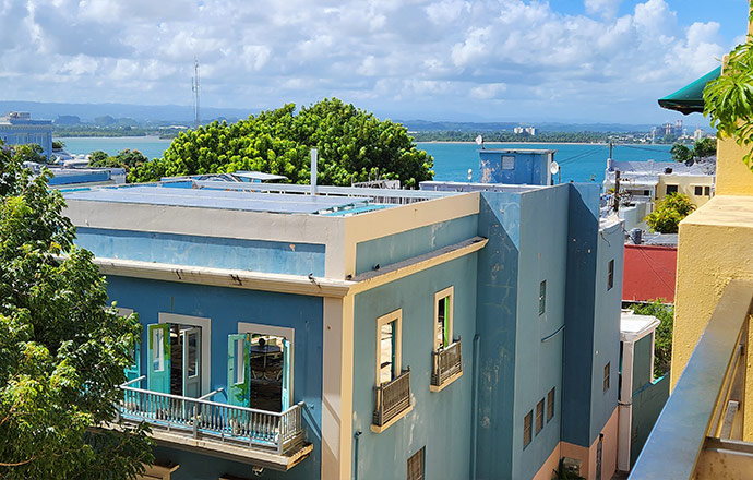 Photo of buildings with rooftop solar near a tropical ocean coast
