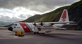 Photo of a U.S. Coast Guard plane in a mountain airport against a cloudy sky.