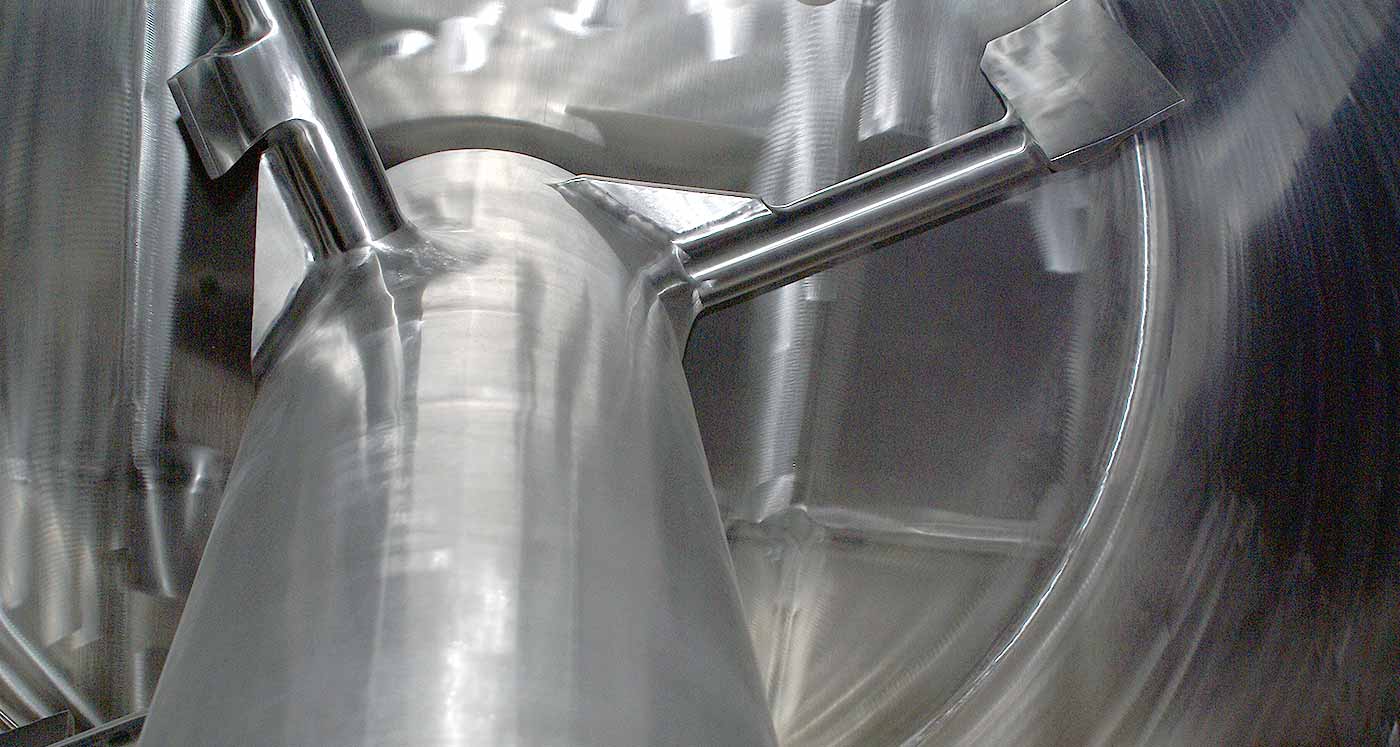 Photo of an interior view of a shiny, large mixer.