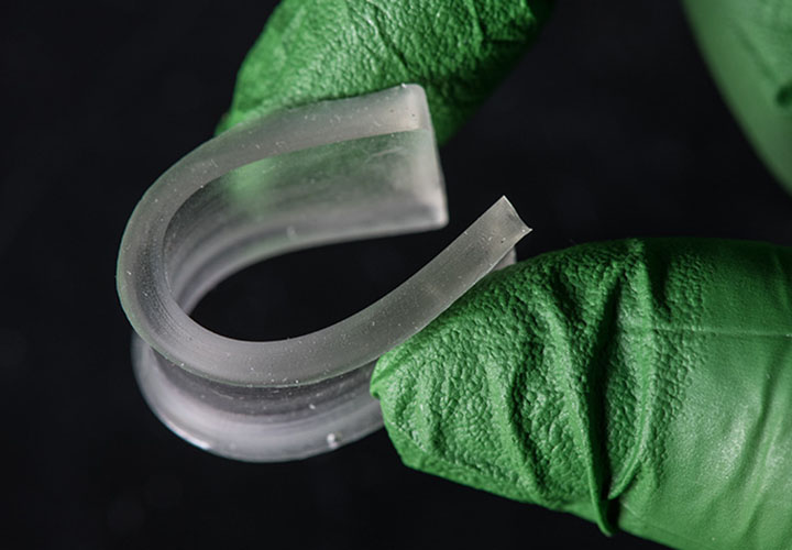 Two fingers bending a rubbery polymer