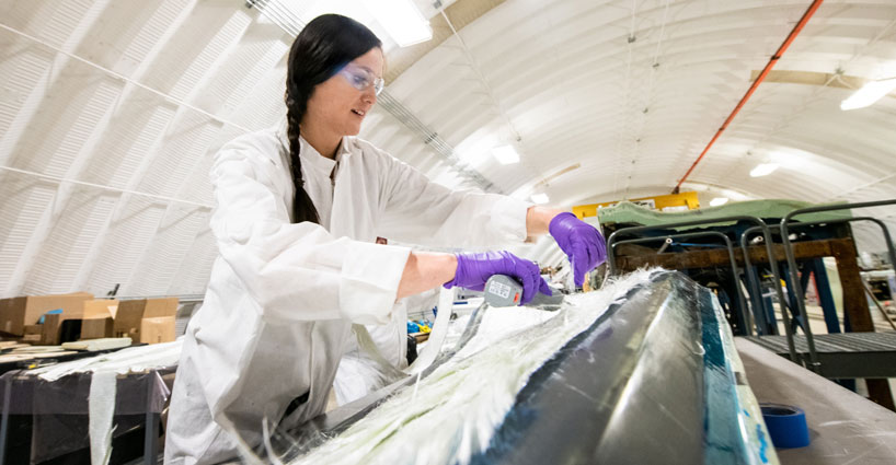 An NREL researcher laying up a turbine blade in a blade mold at the Flatirons Campus.