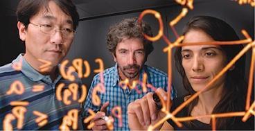 A picture of three people drawing equations on a glass window representing analysis work at NREL.