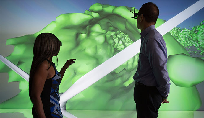 Two people looking at a 3D image of a CFD simulation of a wind turbine blade.