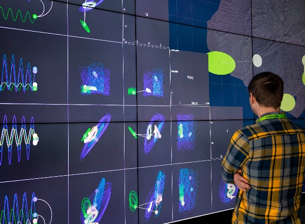 Researcher analyzing 2D data visualizations on a wall-sized screen.