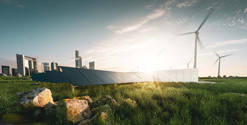Solar panels and wind turbines in a grassy field with a cityscape in the background.
