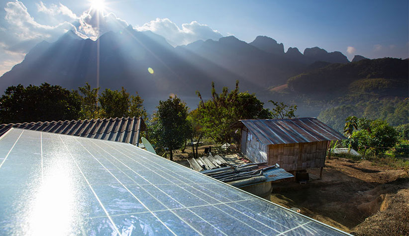 Photo of solar panel on a roof with mountains in the background.