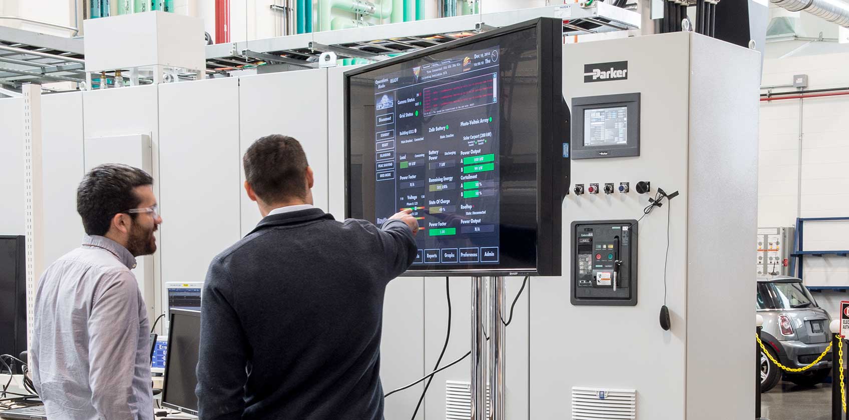 Photo of two men looking at microgrid technology in a laboratory