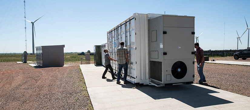 NREL researchers work with the Flex manufactured battery enclosure.