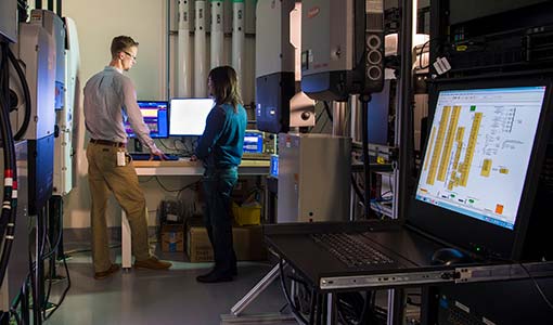 Researchers discuss a computer screen in a laboratory.