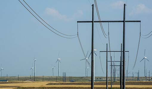 Photo of transmission lines and wind turbines.