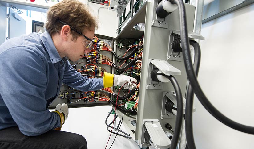 An NREL researcher working in the Power Electronics Bay to measure electrical characteristics that emulate the characteristics of distribution lines in power systems.