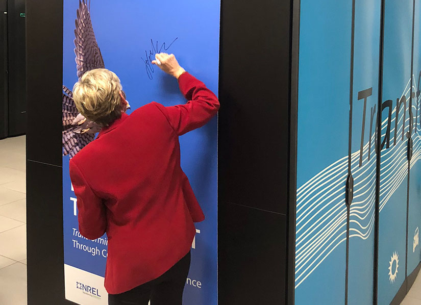 Secretary Granholm signs the side banner of a supercomputer