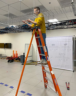 A technician on a ladder works in the data center