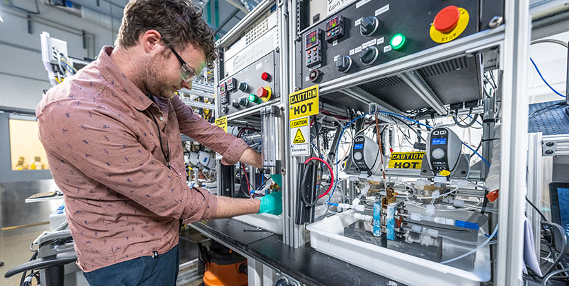 A researcher works on a bench-top test station for low-temperature electrolysis cells in a lab at the Energy Systems Integration Facility.