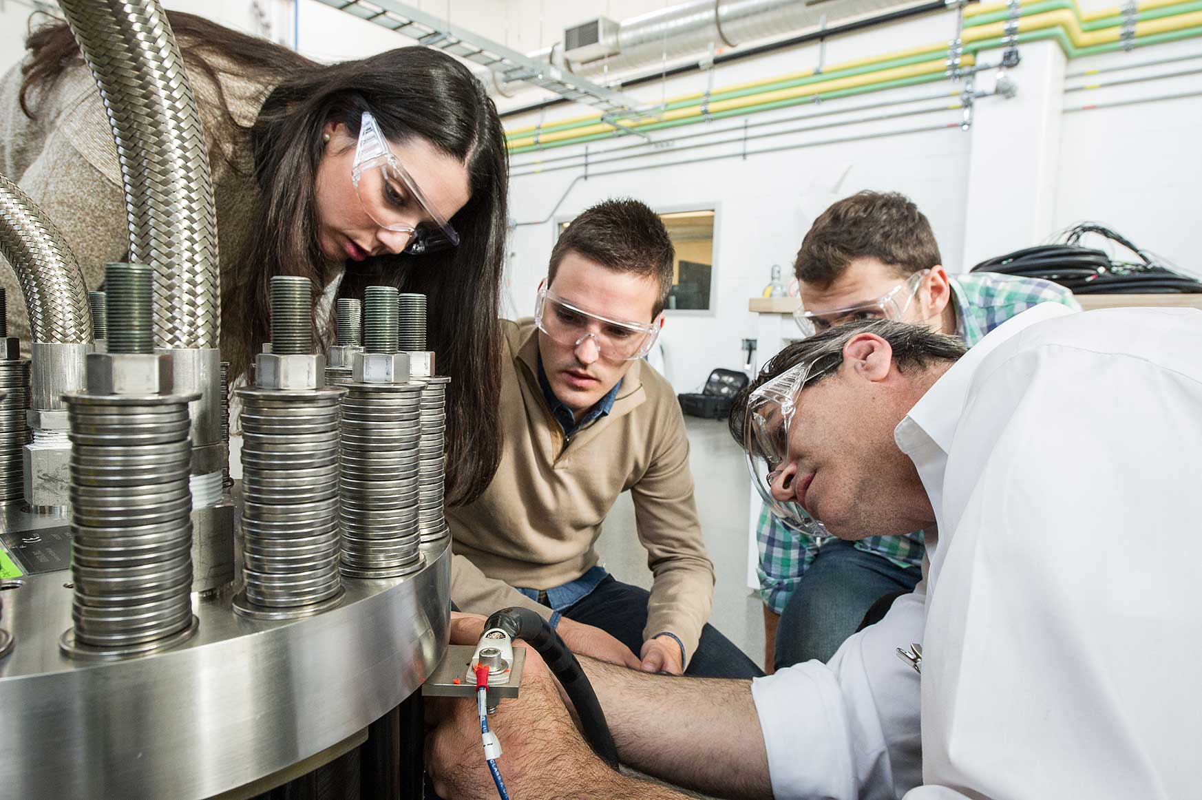 Photo of four researchers working on an electrolyzer stack