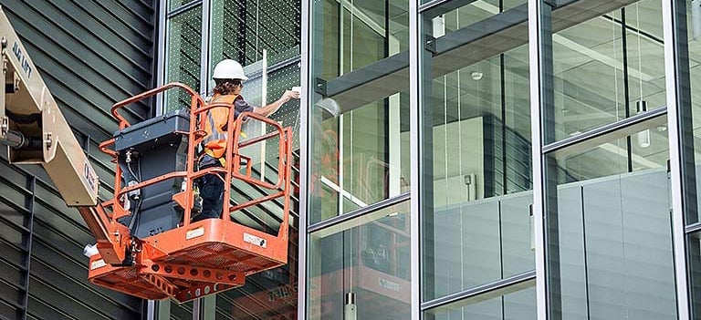 Worker applies window film.